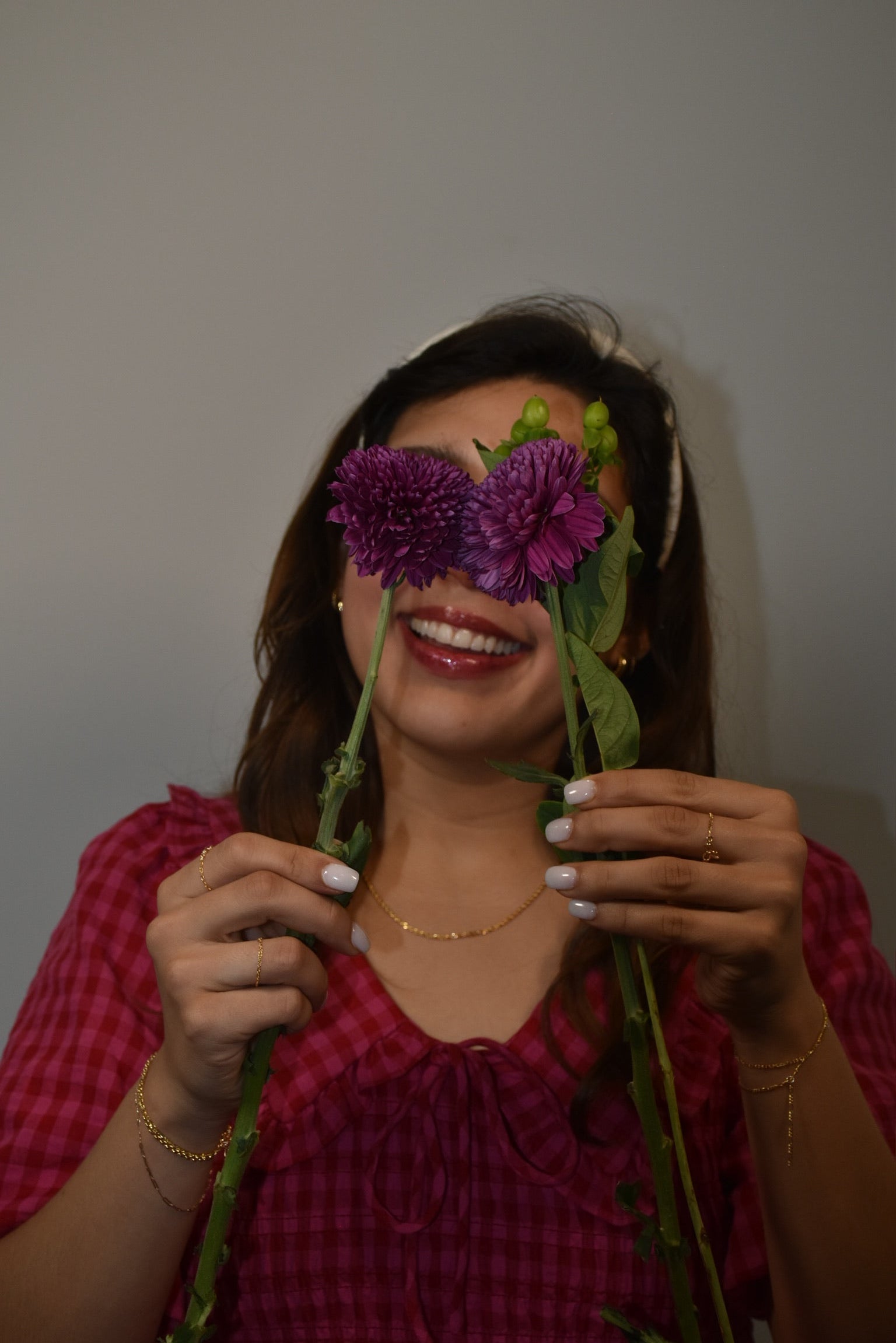 Woman holding flowers with a plain background