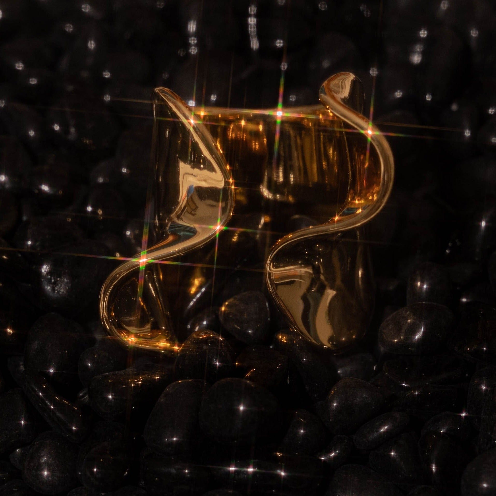 An image of our Kai Ring glowing upon a bed of black beads.
