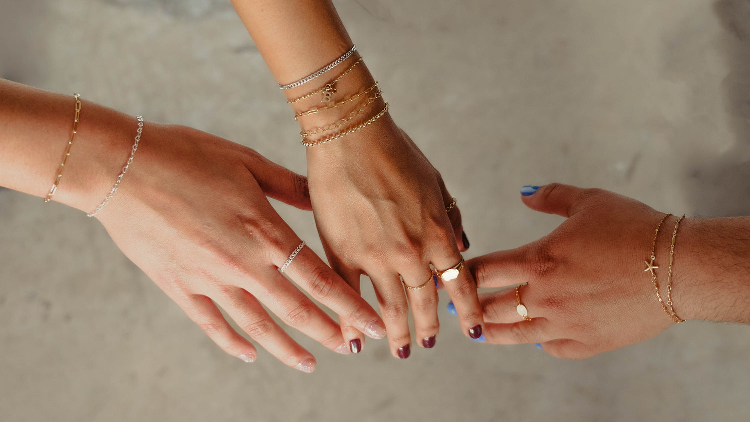 a picture of three friends showing their hands to show off their new permanent bracelets from APT. 144 Jewelry